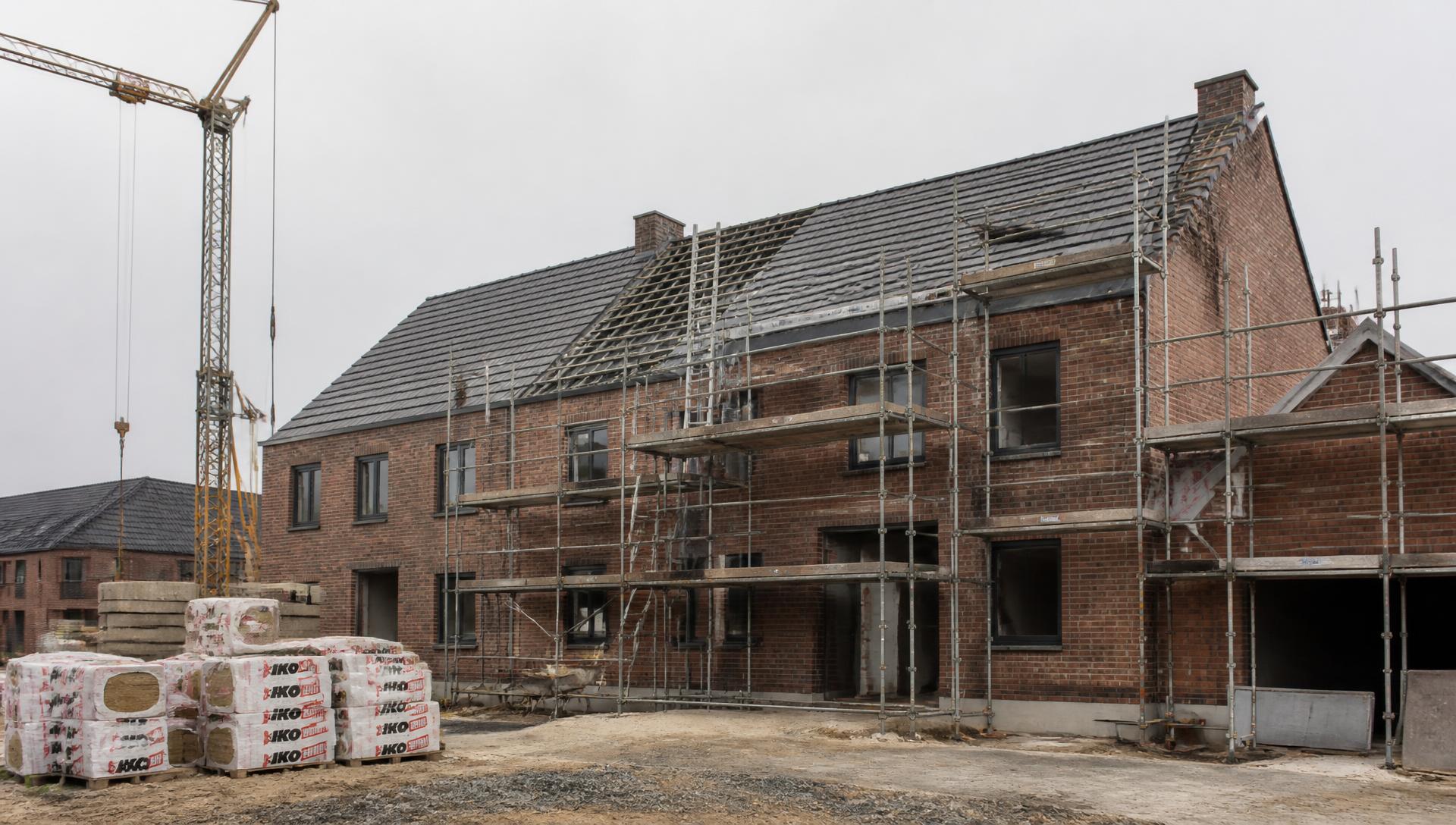 Nieuwbouwwoning in aanbouw met steigers en metselwerk in de omgeving van Antwerpen