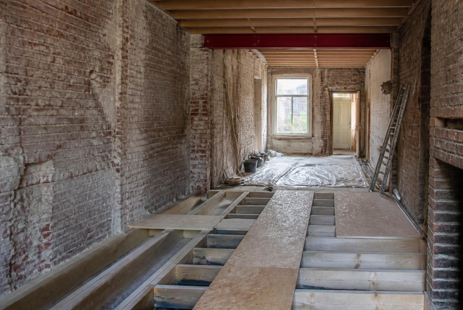 Renovatie van een rijwoning met blootgelegd metselwerk en een nieuwe vloerstructuur